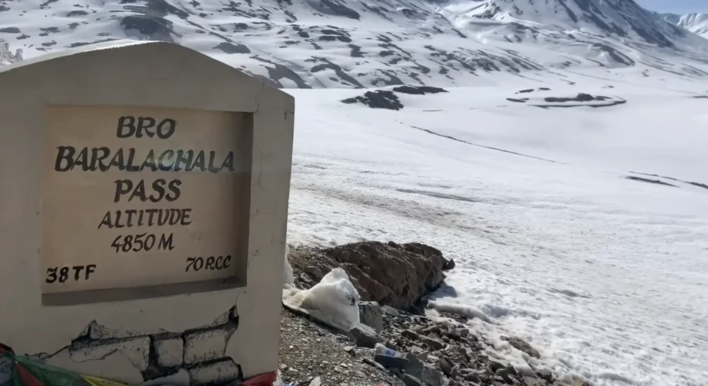 BRO Baralacha Pass at 4,850 m, surrounded by snow-covered mountains, during the Manali to Ladakh road expedition.