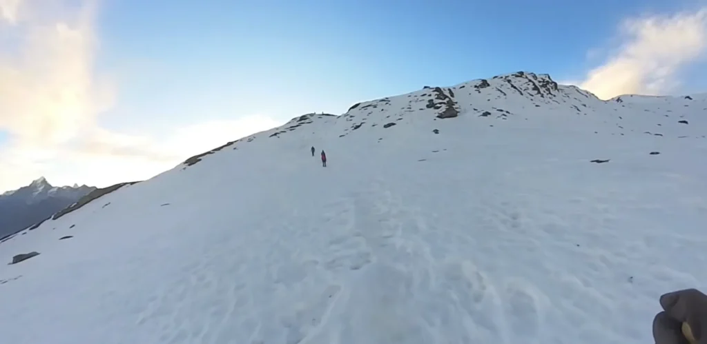 Trekkers at Pangarchulla summit with Himalayan panorama