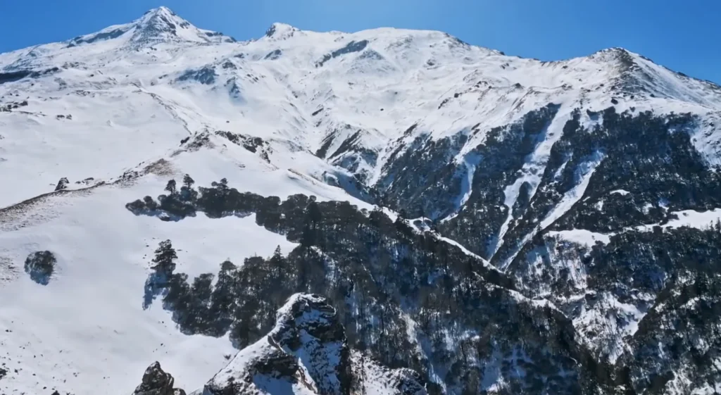 Trekkers on snow ridge near Kuari Pass summit